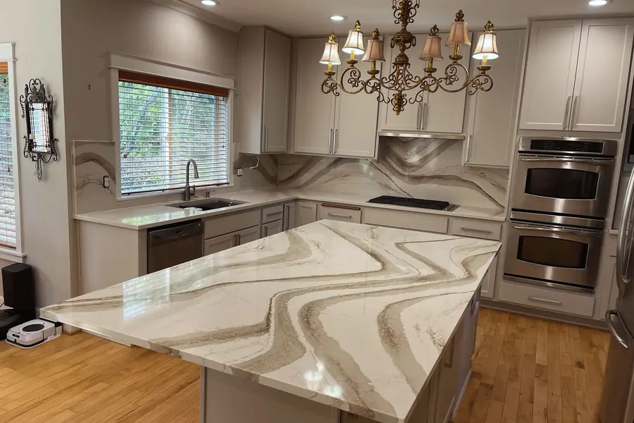 Kitchen island in heavily figured quartz with matching backsplash