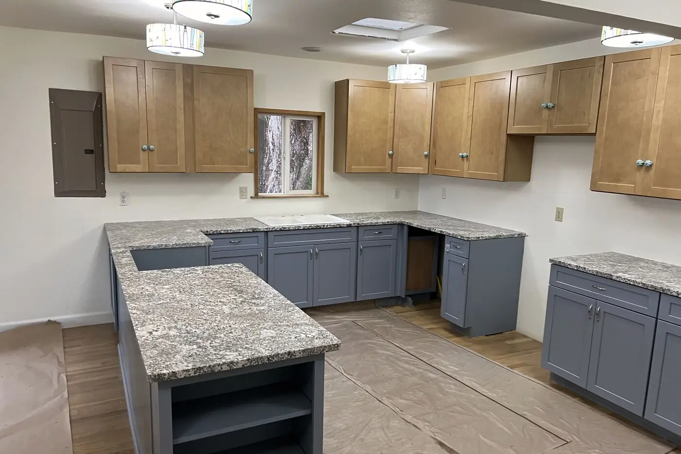 Natural stone with dense speckle, installed on grey cabinets