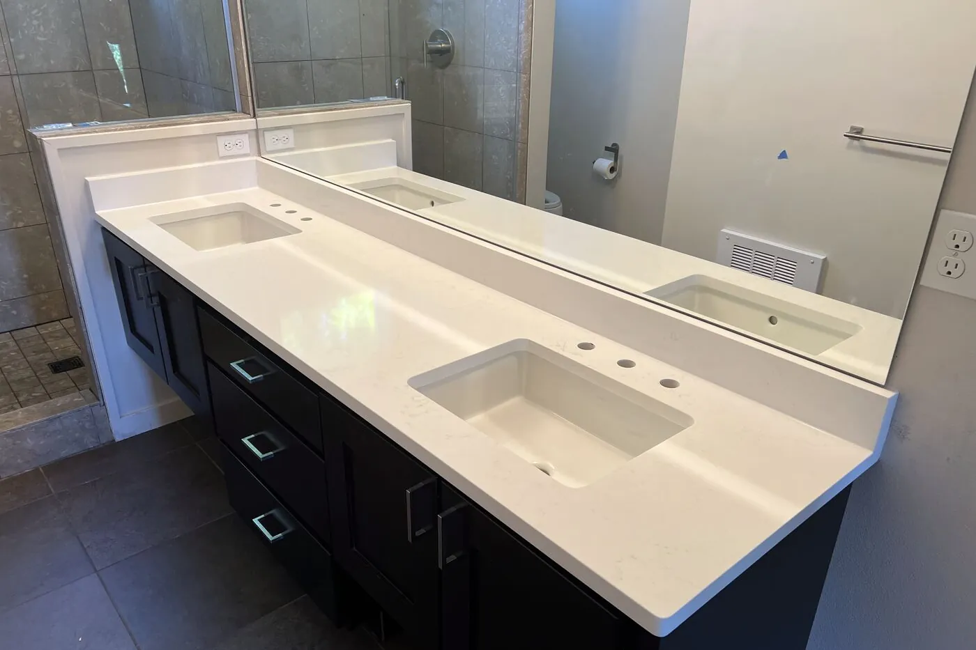 Double vanity top set on dark cabinets, cut and installed by our own crew