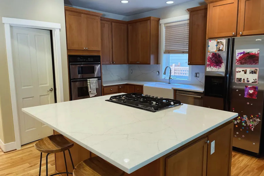 White quartz island with a cooktop cut into it